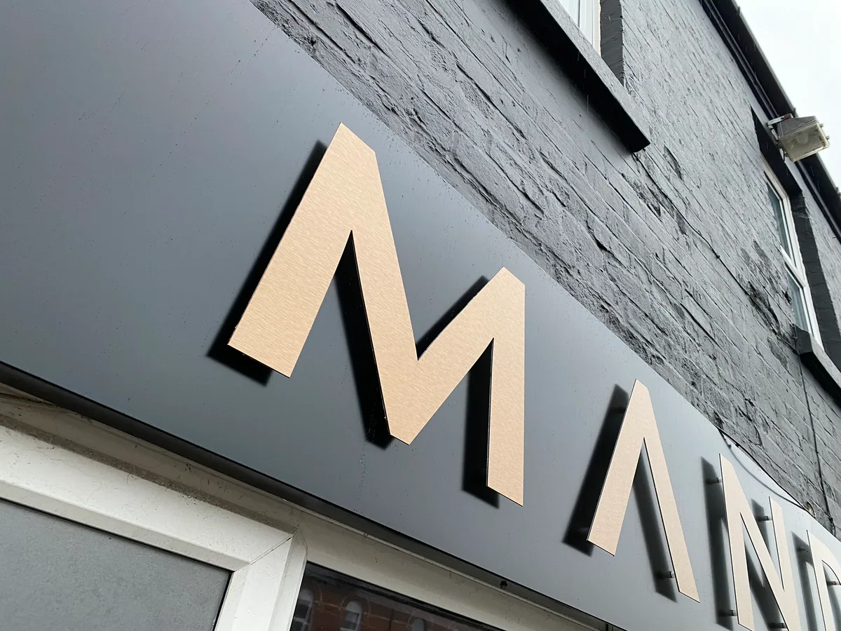 Flat cut letters mounted on a dark shop fascia