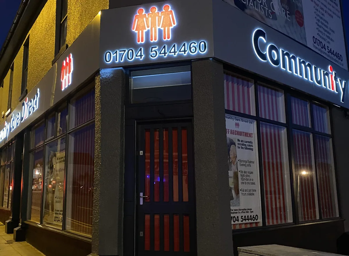 Illuminated shop sign on a building corner