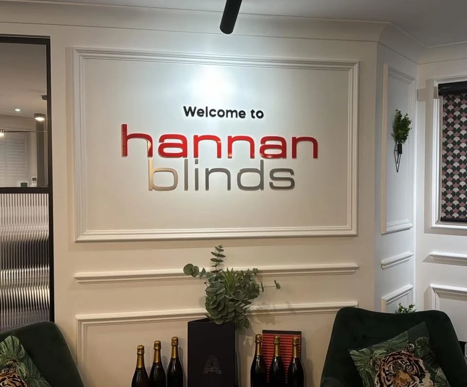 Red and silver Hannan Blinds welcome lettering on an interior showroom wall