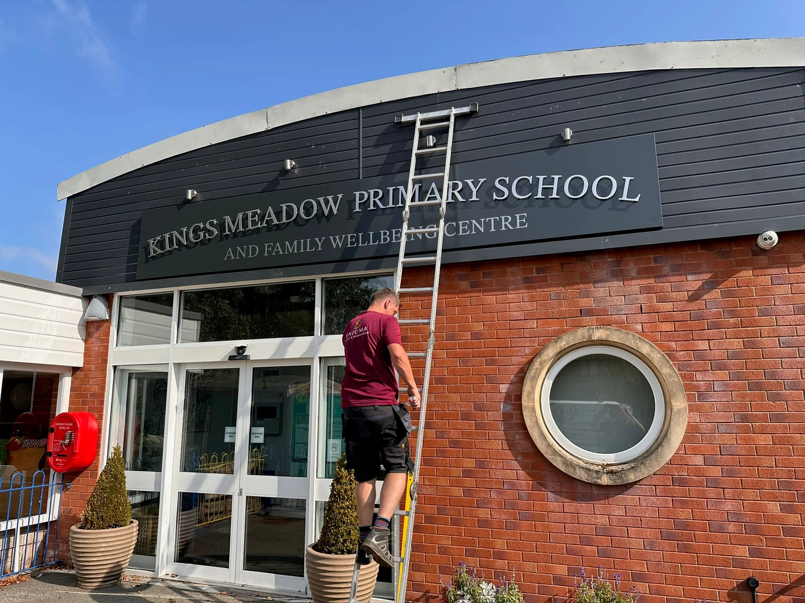 Enigma Signs installer working on Kings Meadow fascia using a ladder