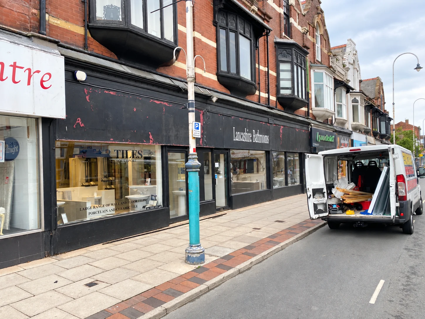 Lancashire Bathrooms shopfront before replacement, showing a worn black fascia