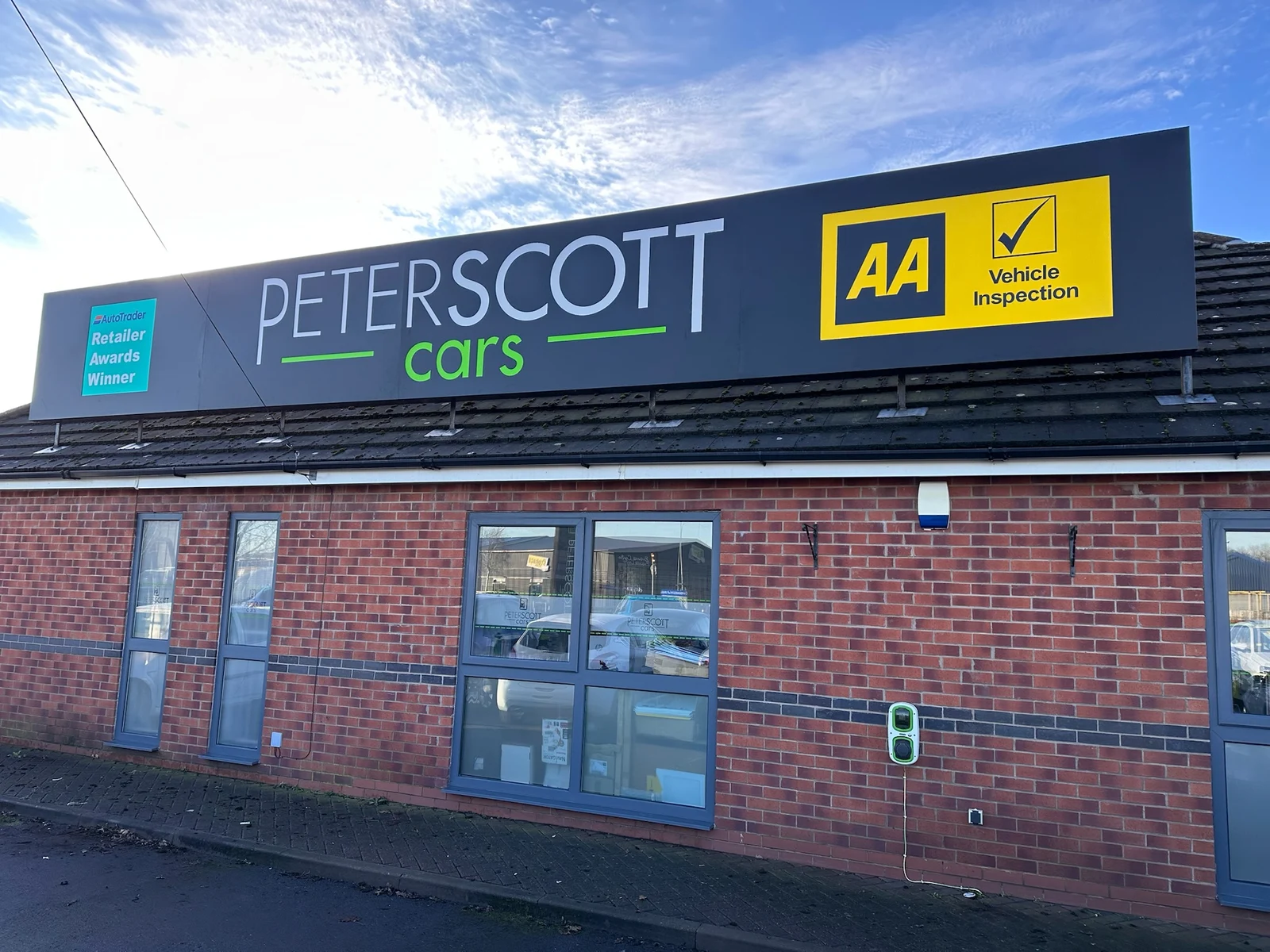 Peterscott Cars large dark fascia with white and green lettering and AA panel