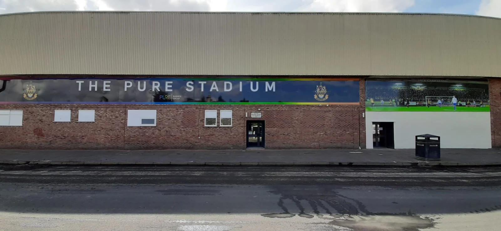 Long printed ACM fascia displaying The Pure Stadium name and football photographs