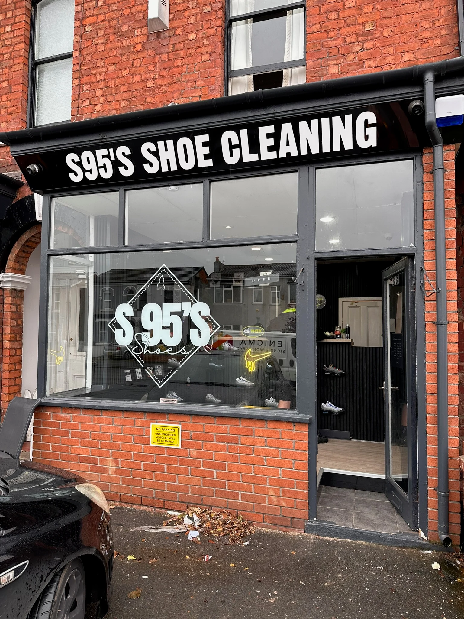 S95’s Shoe Cleaning black flat ACM fascia with white lettering above the shop window