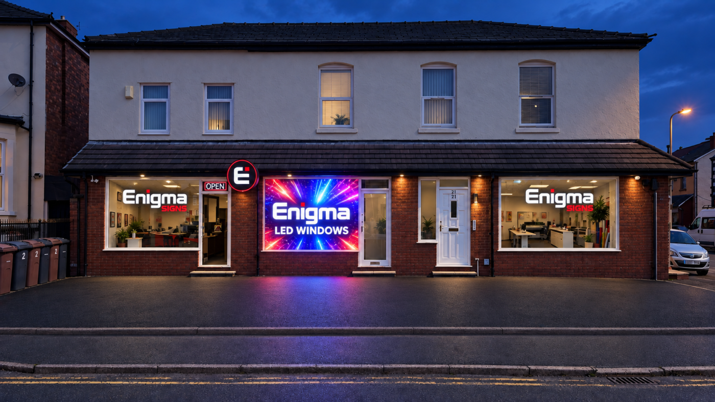 Enigma Signs shopfront illuminated at dusk