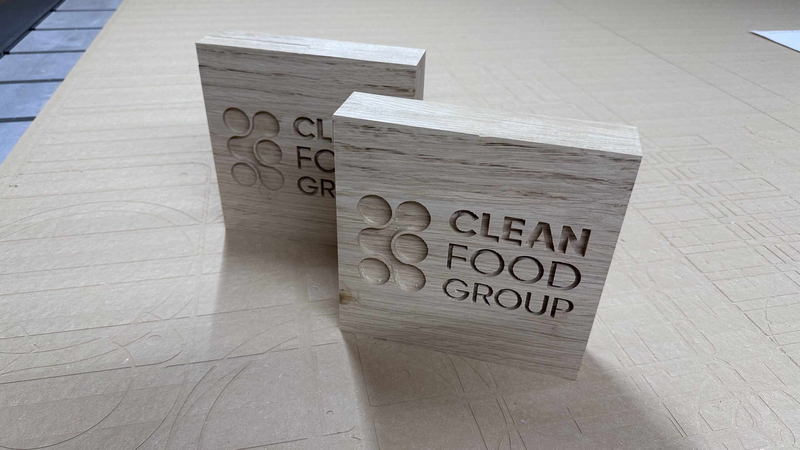 Close view of the recessed Clean Food Group lettering and logo in oak before waxing