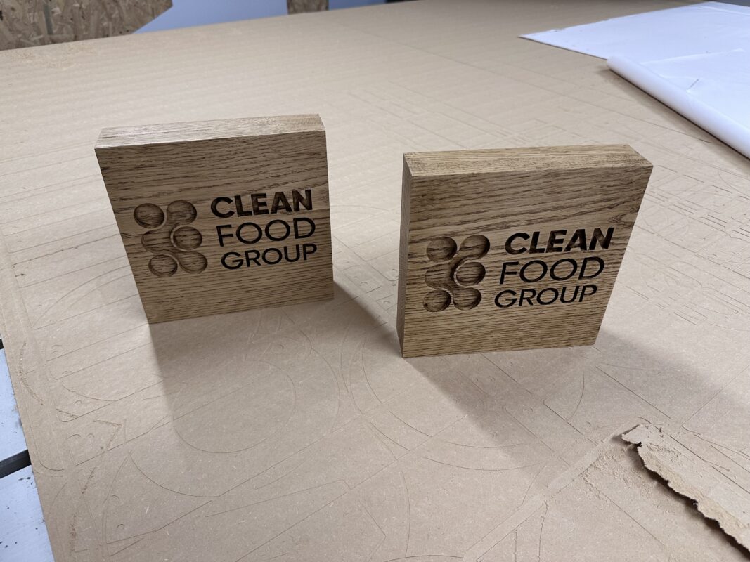 Two waxed French oak desktop blocks engraved with the Clean Food Group logo